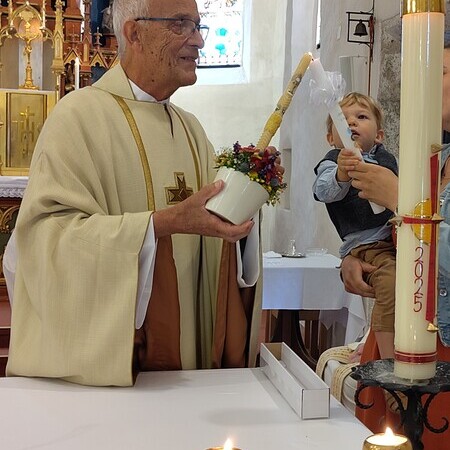 Sein jüngstes Taufkind Jonathan überbrachte Pfarrer Leopold  Bösendorfer am Beginn des Festgottesdienstes das Licht der Osterkerze