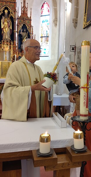 Sein jüngstes Taufkind Jonathan überbrachte Pfarrer Leopold  Bösendorfer am Beginn des Festgottesdienstes das Licht der Osterkerze