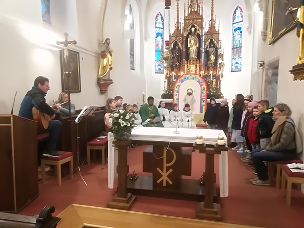 Die Erstkommunionkinder mit ihrem Religionslehrer Andreas Garstenauer (l.), Pfarrer Samuel Igwe und Pastoralassistentin Roswitha Bramauer (re.)